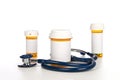 Pill bottles with blank labels and stethoscope Royalty Free Stock Photo