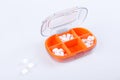 Pill box with colorful pills and vitamins. Plastic red container with cells for medicines. Health concept. Selective focus. Royalty Free Stock Photo