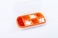 Pill box with colorful pills and vitamins. Plastic red container with cells for medicines. Health concept. Selective focus. Royalty Free Stock Photo