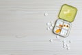 Pill box with medicaments on white wooden table, flat lay. Space for text Royalty Free Stock Photo