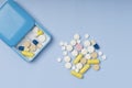 Pill box with pills on blue background.  box container of tablets, vitamins for routine treatment. Top view Royalty Free Stock Photo