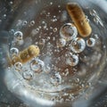 Pill and Capsule Dissolving in Water Royalty Free Stock Photo