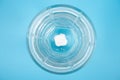 Pill dissolves in a glass of water on a blue background top view Royalty Free Stock Photo