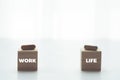 Pill or drug capsule that stamp the word work or life is placed on the wooden cube. The decision to choose between work or life.