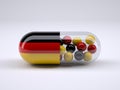 Pill with German flag wrapped around it and red ball inside