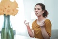 Woman sneezing and taking pill while having allergy to flowers Royalty Free Stock Photo