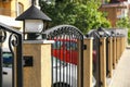 Pillar with streetlight on metal fence outdoors. space for text