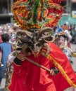 Portrait of man dressed as a red devil in the foreground dancing at the Diablada Pillarena parade in the city of Pillaro - Ecuador