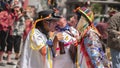 Three men dressed as Guaricha in the foreground speaking at the Diablada Pillarena parade in the city of Pillaro - Ecuador