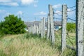 Pillars with barbed wire among the grass