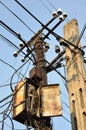 Pillars with old rusty box and crossing cables Royalty Free Stock Photo