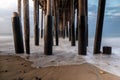 Pillars of Ventura Pier, early morning. Beach sand and rocks; smooth ocean and colored sky. Royalty Free Stock Photo