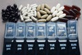 Pillbox by day next to different dietary supplements and tablets Royalty Free Stock Photo