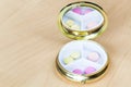 Pillbox with mirror with pink and yellow pills Royalty Free Stock Photo