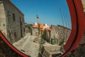 Pillory on square with old houses reflected in street mirror