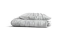 A pillow and blanket in smooth white fabric are stacked in a column. Royalty Free Stock Photo