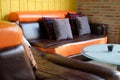 pillow on brown orange leather sofa couch beside yellow wall Royalty Free Stock Photo