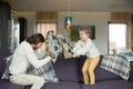 Pillow fight between father and little son in living room