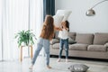 Pillow fight. Kids having fun in the domestic room at daytime together Royalty Free Stock Photo