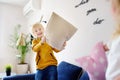 Pillow fight. Mischievous preschooler children jumping on a sofa and hitting each other with pillows.Active games for siblings at