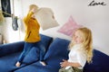 Pillow fight. Mischievous preschooler children jumping on a sofa and hitting each other with pillows. Boy and girl play together Royalty Free Stock Photo