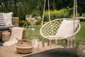 Pillow on hanging chair and basket on carpet in the garden during spring