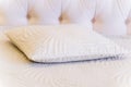 A pillow with a leaf design sits on a bed Royalty Free Stock Photo