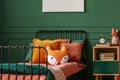 Pillow on single bed in dark green teenager bedroom