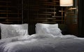 Pillows and bed sheet in the room of hotel,light on in travel hotel concept