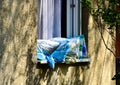 Pillows being aired in the open window. spring lights. stucco exterior elevation