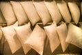 Pillows of white color suspended on a crossbeam in rows. Household items, light industry