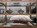 Pillows on wooden shelves. Cotton towels neatly folded. Beautiful table setting with many details. Designer plates and bowls Royalty Free Stock Photo