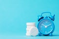 Pills and alarm clock on a blue background. Its time to take medicine Royalty Free Stock Photo