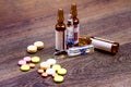 Pills and ampules on wooden background