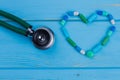 Pills arranged in a heart shape and stethoscope. Royalty Free Stock Photo