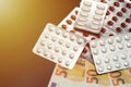 Pills in blister on euro banknotes. Medicine concept. Rising cost of health care with spilled medicine. Drug abuse. Addiction. Royalty Free Stock Photo