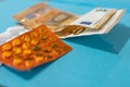 Pills blister on money euro banknotes for pharmaceutical cost. Rising prices of healthcare system. Medical on blue background. Royalty Free Stock Photo