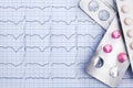 Pills in blister packs on cardiogram graph papepr background