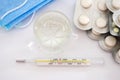 Pills in blister packs glass of water, thermometer and medical mask on white. Health concept. View from above. Royalty Free Stock Photo