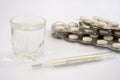 Pills in blister packs glass of water and thermometer on white. Health concept. Royalty Free Stock Photo