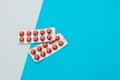 Pills in blister packs of vitamins on a blue background. Royalty Free Stock Photo