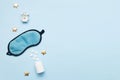 Pills, bottle, sleeping mask and white alarm clock with stars on blue pastel background. Concept Insomnia, sleep