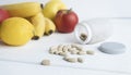 Pills and capsules in wooden spoon with fresh fruits.Multivitamins Royalty Free Stock Photo