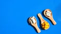 Pills and capsules on wooden spoons on blue background. Hard light and shadows. Copy space. Vitamins prebiotics probiotics. Drug