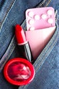 Pills condom and lipstick in denim pocket. Royalty Free Stock Photo