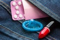 Pills condom and lipstick in denim pocket. Royalty Free Stock Photo