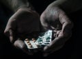 Pills in the dirty hands of a poor man on a black background. Royalty Free Stock Photo