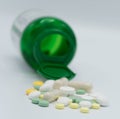 Pills falling out a green bottle. Royalty Free Stock Photo