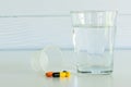 Pills and a glass of drinking water with pill cup Royalty Free Stock Photo