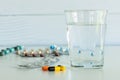 Pills and a glass of drinking water with some pill packages Royalty Free Stock Photo
